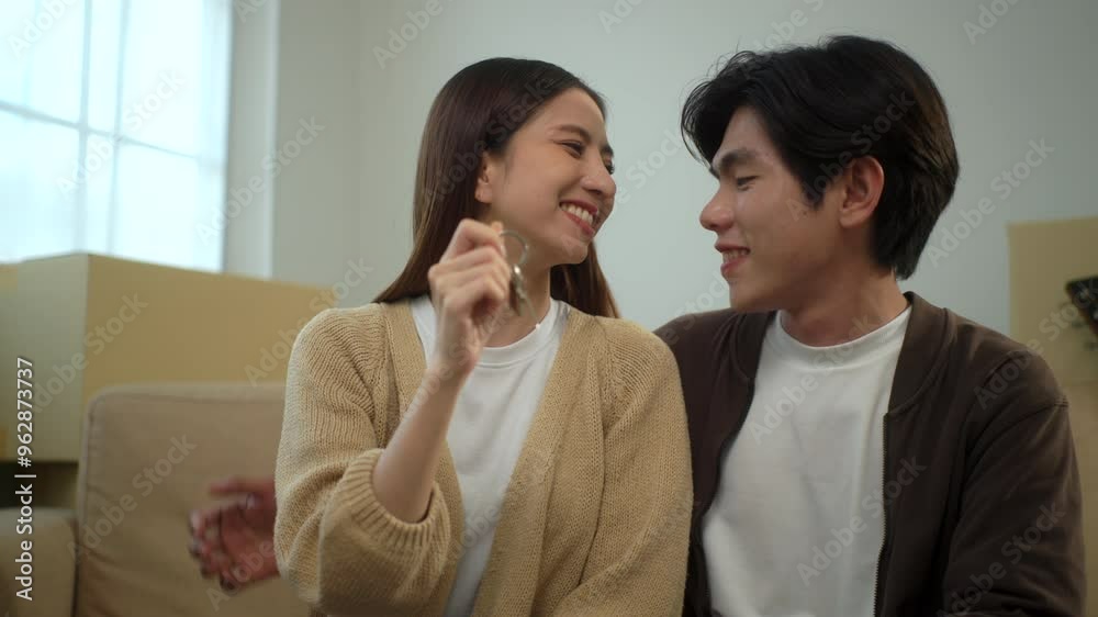 Young cheerful couple smiling to each other while girlfriend holding house key after moving to new house with pile of cardboard boxes, relocating real estate apartment concept.
Young cheerful couple smiling to each other while girlfriend holding house key after moving to new house with pile of cardboard boxes, relocating real estate apartment concept.