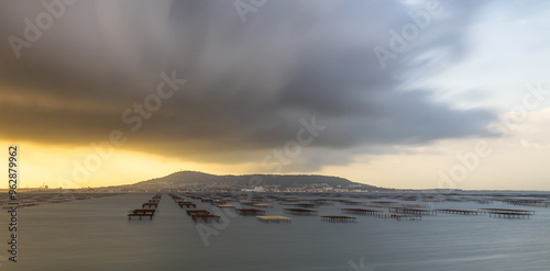 Mont Saint Clair and the Thau lagoon, with its oyster tables, under a stormy sky, in Hérault, Occitanie, France