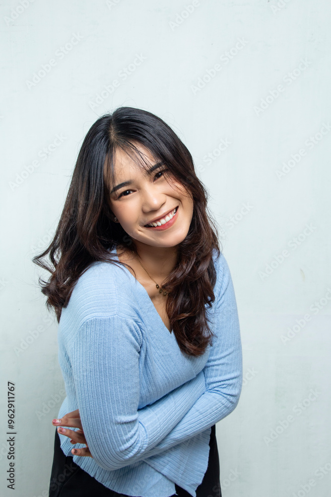 closeup of asian beauty face posing for camera and hugging her own body, the woman is wearing blue casual top, long flowing hair and smiling freely, isolated on white closeup of asian beauty face posing for camera and hugging her own body, the woman is wearing blue casual top, long flowing hair and smiling freely, isolated on white