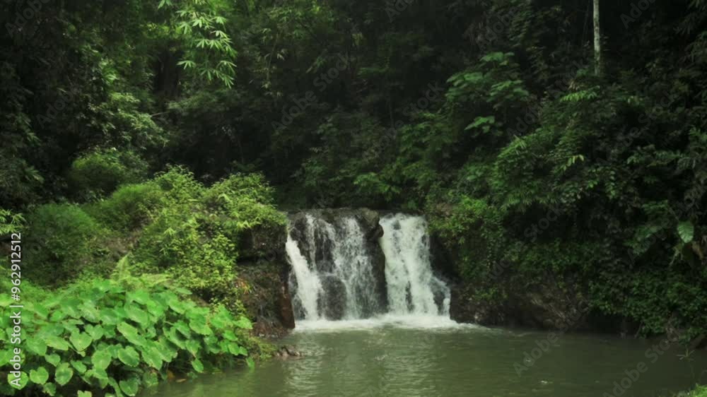 Drone view beautiful scenery of waterfall in tropical rainforest during rainy season. Water stream flowing over the cascade through lush foliage vegetation in the jungle. Wild nature background. Drone view beautiful scenery of waterfall in tropical rainforest during rainy season. Water stream flowing over the cascade through lush foliage vegetation in the jungle. Wild nature background.
