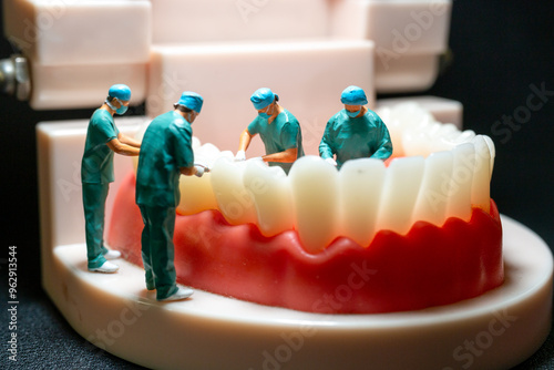 Miniature figurines of surgeons working on a large model of human teeth photo