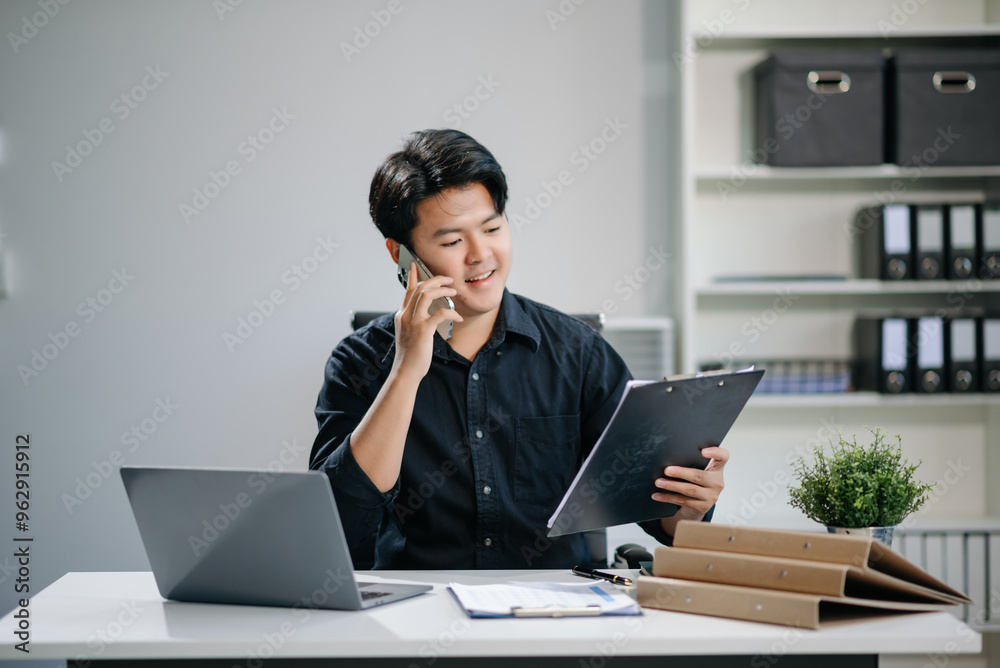 Young businessman working with working notepad, tablet and laptop documents talking on the smartphone, tablet and laptop Young businessman working with working notepad, tablet and laptop documents talking on the smartphone, tablet and laptop