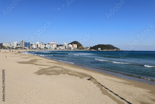 Haeundae-gu, Busan, South Korea - January 10, 2021: Wave on the sand of Songjeong Beach with the background of tourists 