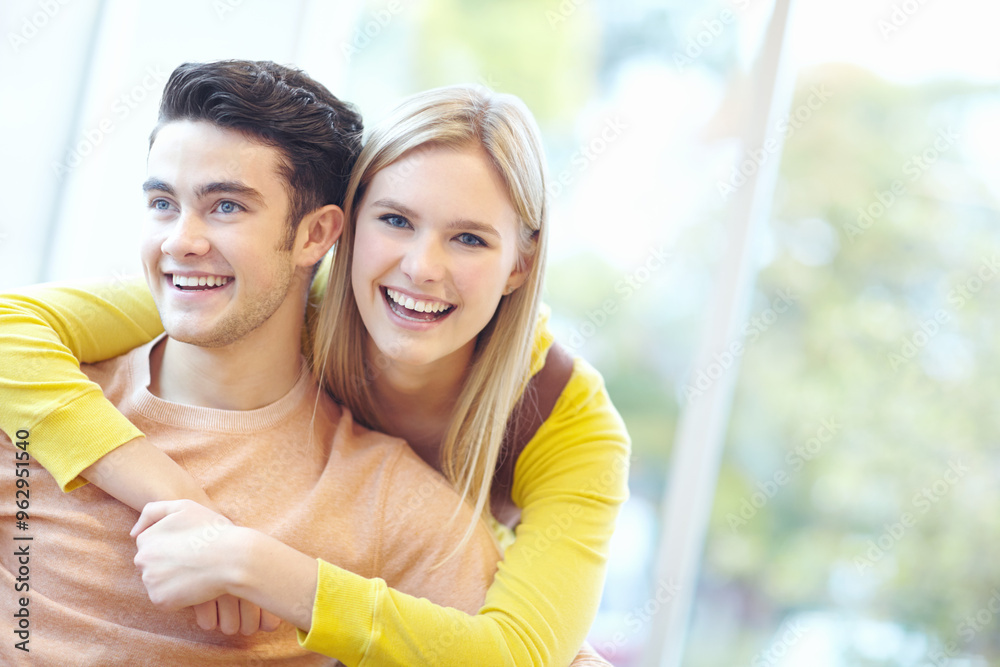 Fototapeta premium Smile, couple and hug in home for love, connection and laugh to relax together. Happy man, woman and embrace in living room for healthy relationship, trust and commitment to funny partner for support