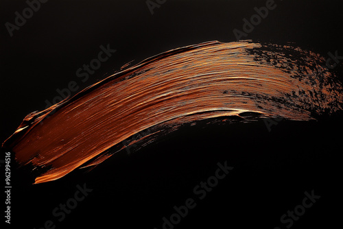 bright brown brush stroke of paint on black background
