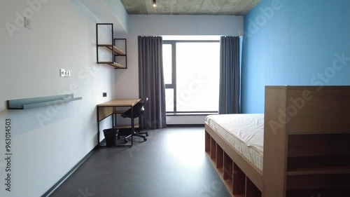 Simple student-style dorm bedroom. Hostel dormitory room. Campus