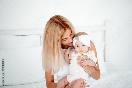 mom and baby hug and kiss, a young mother gently hugs a newborn baby girl holding him in her arms, maternal love and care, a young family, mother and daughter