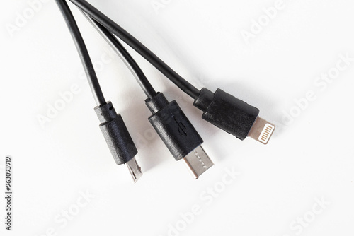 Universal black 3 in 1 charging cable with different charging connectors on a white background, close-up. Type-c, usb-c, micro-usb photo