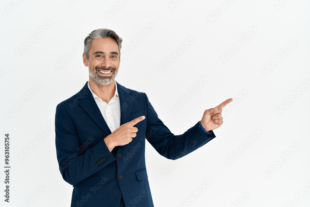 Happy mature man ceo executive pointing aside at copy space isolated on white wall. Smiling middle aged businessman professional manager wearing suit looking at camera advertising business service. Happy mature man ceo executive pointing aside at copy space isolated on white wall. Smiling middle aged businessman professional manager wearing suit looking at camera advertising business service.