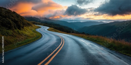 A winding asphalt highway stretching through lush green mountains under a dramatic sunset sky, with vibrant clouds, capturing the beauty of a serene road journey