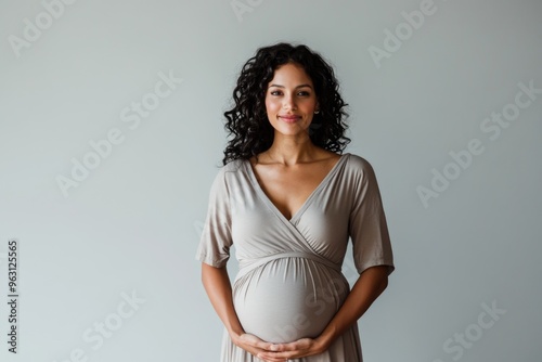 Wallpaper Mural Portrait of a happy smiling pregnant Indian woman on the light grey background, concept of motherhood, expecting baby and parenthood Torontodigital.ca