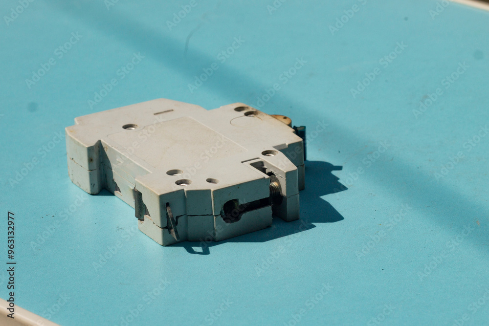 Fototapeta premium a used or obsolete circuit breaker with a blue background. closeup of electrical protection equipment in a home or industrial building