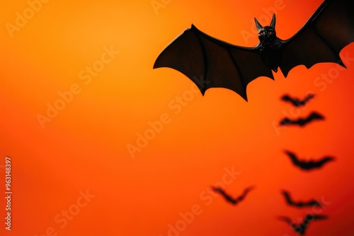 Dynamic Bats Against a Bold Orange Halloween Backdrop