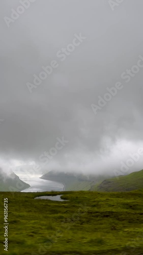 Car point of view traveling through the landscape of the Faroe Islands. Located on the outskirts of Tórshavn on the island of Streymoy. Tourists stop to take in the views of Kaldbaksfjørður Fjord. photo