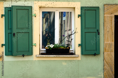 Vintage facade of the residential house. One window with green wooden shutters, plants in flower pot.  Traditional view of the house in medieval Bamberg, Upper Franconia district in Bavaria, Germany