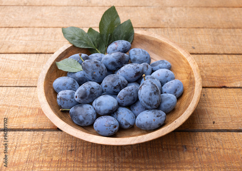 Frisch geerntete Ökologische Zwetschgen in einer Holzschale