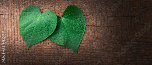 Grünes Herzförmiges Blatt auf altem Holzbrett