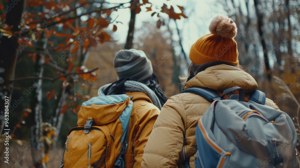 Two people wearing backpacks and hats are walking through a forest. Scene is peaceful and serene, as the two people are enjoying a leisurely walk in nature Two people wearing backpacks and hats are walking through a forest. Scene is peaceful and serene, as the two people are enjoying a leisurely walk in nature