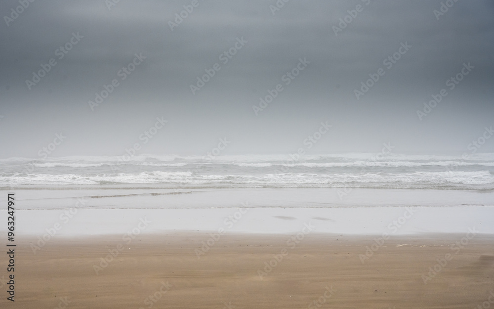 Wet Sand and Dark Clouds Fame The Pacific Surf Off Cannon Beach Wet Sand and Dark Clouds Fame The Pacific Surf Off Cannon Beach