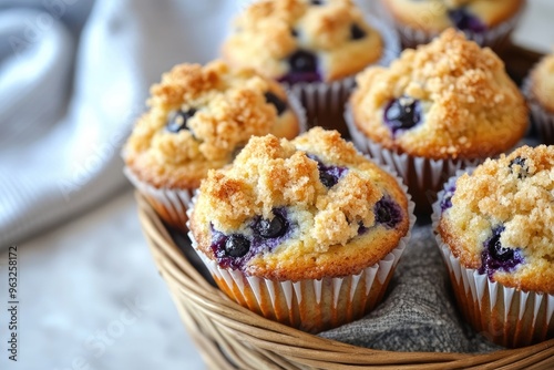 Freshly baked blueberry muffins with a golden crumb topping, arranged in a basket