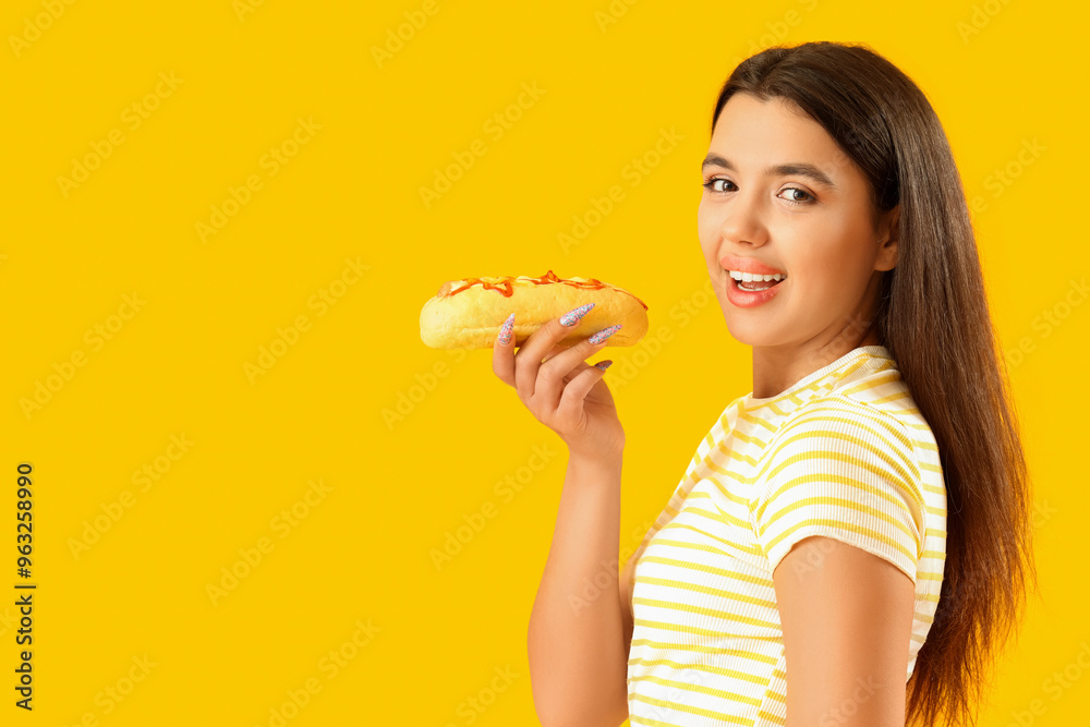 Pretty young woman with tasty hot dog on yellow background Pretty young woman with tasty hot dog on yellow background