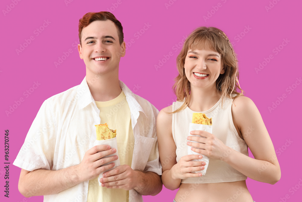 Young couple with tasty sandwich wraps on purple background Young couple with tasty sandwich wraps on purple background