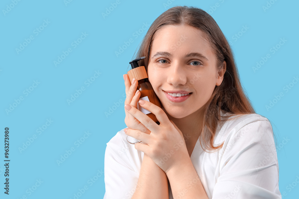 Young woman with bottle of cream on blue background, closeup Young woman with bottle of cream on blue background, closeup