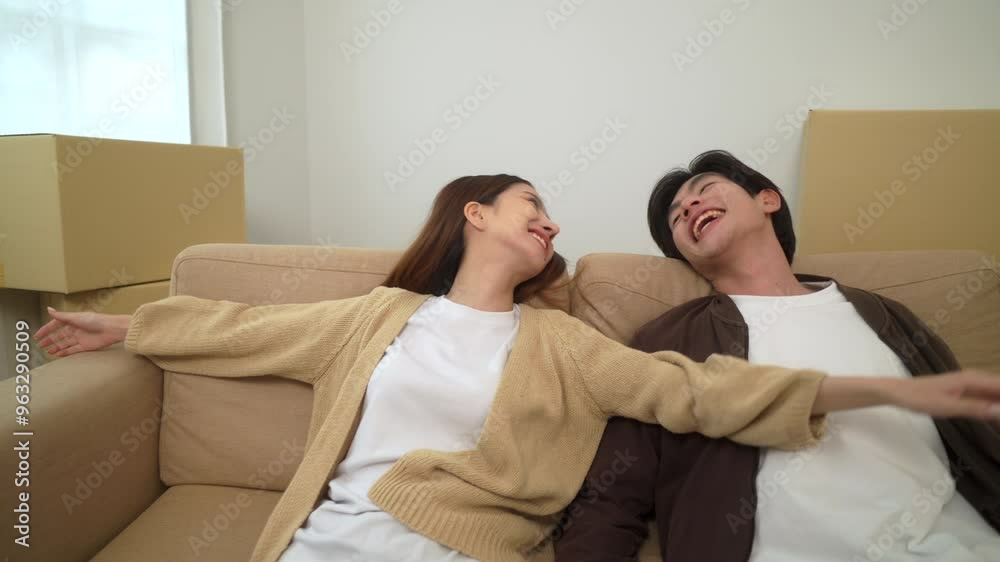 Young happy couple resting on sofa in living room with full of cardboard boxes after moving to new house, cheerful couple pleasant in moving day in new real estate, relocating new apartment concept.
Young happy couple resting on sofa in living room with full of cardboard boxes after moving to new house, cheerful couple pleasant in moving day in new real estate, relocating new apartment concept.