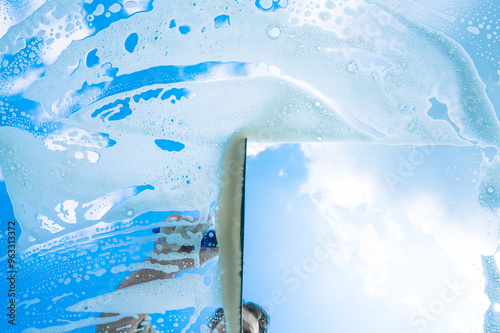 Fenster putzen mit Schaum und Abzieher / Fensterputzer bei der Arbeit