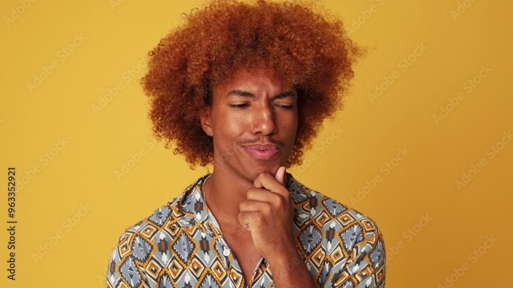 Happy guy, thinking about an idea, making choice, saying yes, isolated on yellow background Happy guy, thinking about an idea, making choice, saying yes, isolated on yellow background