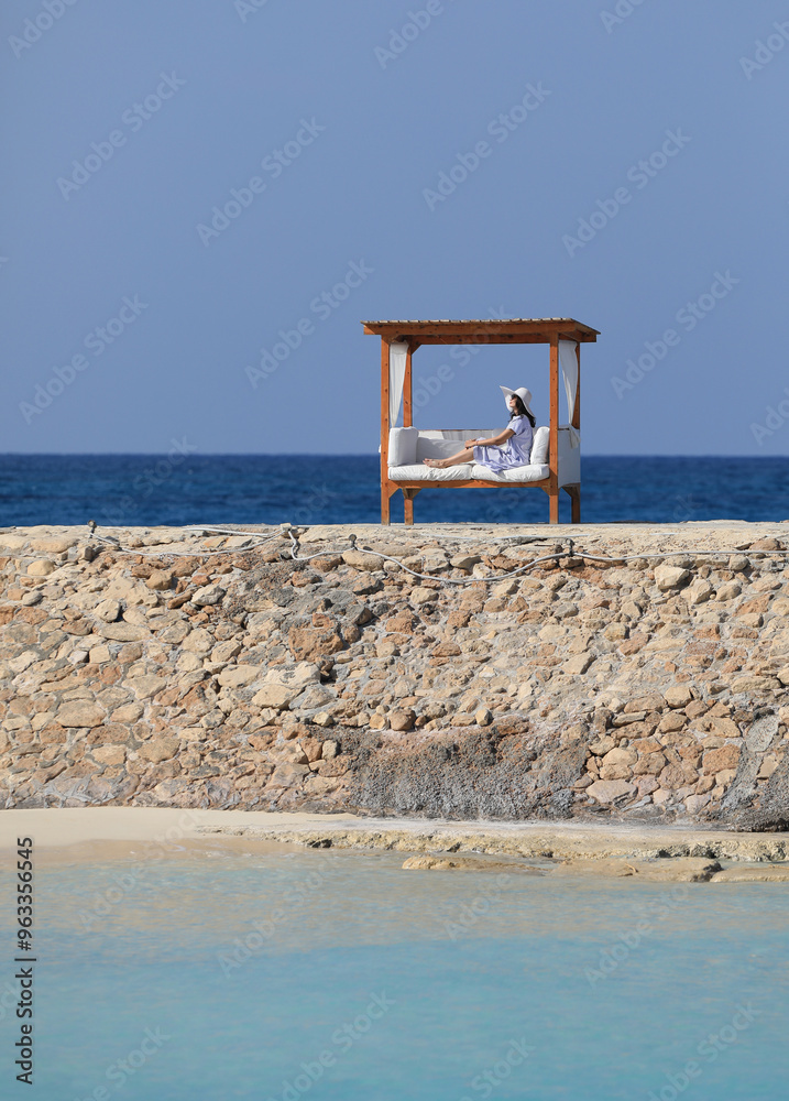 beautiful brunette woman relaxing in gazebo on seashore beautiful brunette woman relaxing in gazebo on seashore