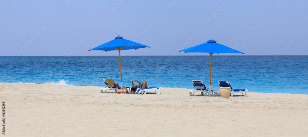Obraz premium seaside resort beach with white sand and sun umbrellas