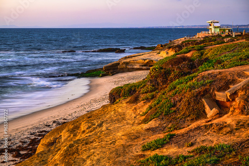 2023-12-31 ROCKY LA JOLLA SHORE WITH VEGETATION AND A SNADY BEASH WITH A LIFEGUARD STATION NEAR SAN DIEGO CALIFORNIA photo