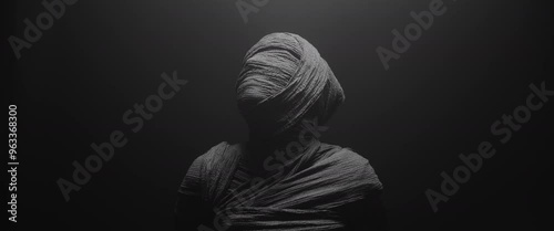 A mummy of a woman against the dark background raises her head and looks around 