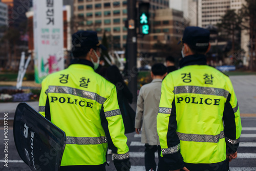 Korean police squad formation in protective uniform with "Police" logo, policemen patrol maintain public during political demonstration protest rally in the streets of Seoul city center, South Korea