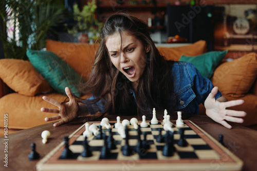 Woman playing chess with angry expression on face at table in front of couch