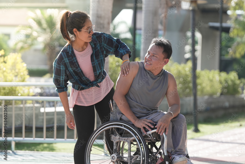 Obraz premium Girlfriend and Disabled man in wheelchair at the park. Muscular dystrophy. Young man in wheelchair and joyful woman at park.