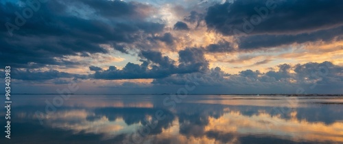 Expansive cloudy sky reflecting on a calm sea. photo