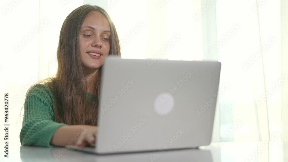 Woman working on laptop in business setting. Focused professional managing business online. Smiling woman engaged in online business tasks. Entrepreneur using laptop for online business operations. Woman working on laptop in business setting. Focused professional managing business online. Smiling woman engaged in online business tasks. Entrepreneur using laptop for online business operations.