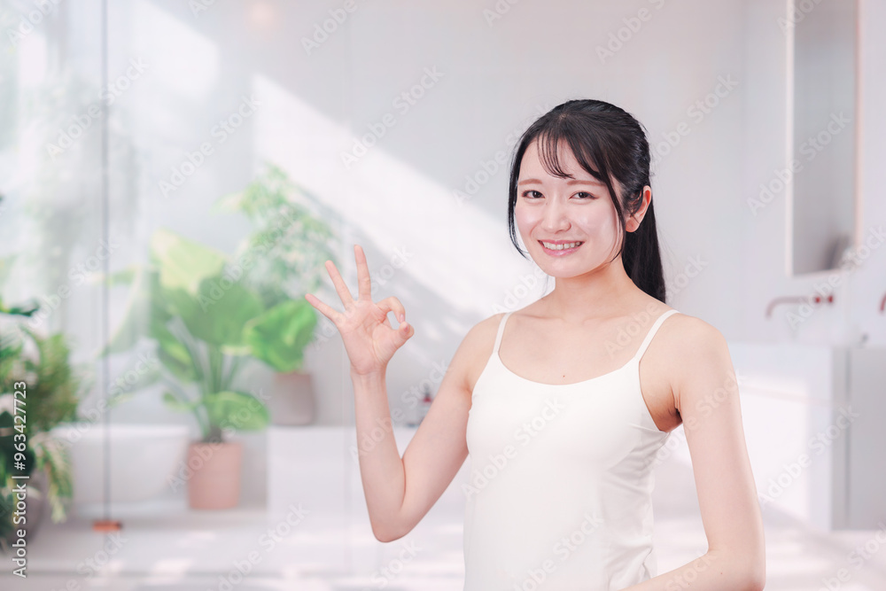 笑顔でビューティーケアをする若い女性 笑顔でビューティーケアをする若い女性
