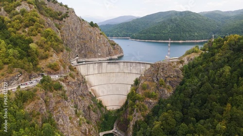 Carpathian mountains with Vidraru dam and lake. Top cinematic aerial view. 4K drone footage. Traveling around Romania. The most famous car road in Europe photo