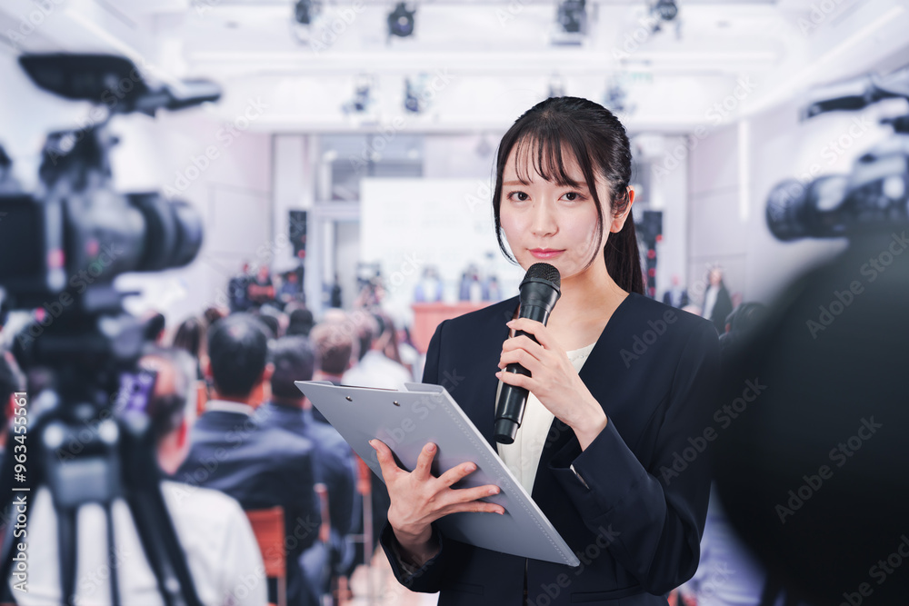 Fototapeta premium 記者会見場からレポートをする女性記者
