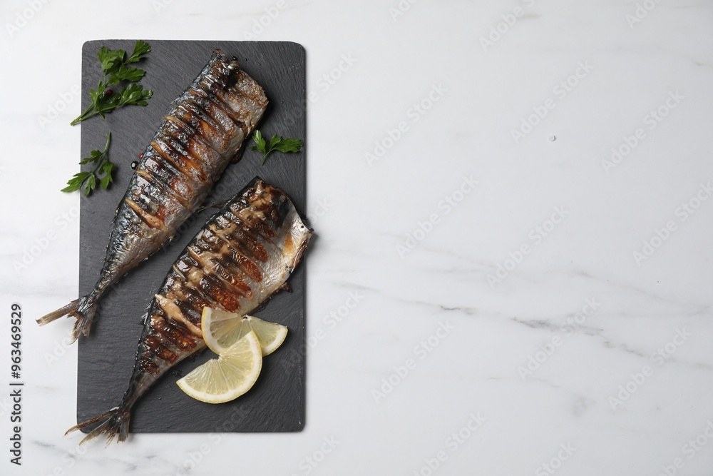 Delicious grilled mackerel, parsley and lemon on white marble table, top view. Space for text Delicious grilled mackerel, parsley and lemon on white marble table, top view. Space for text