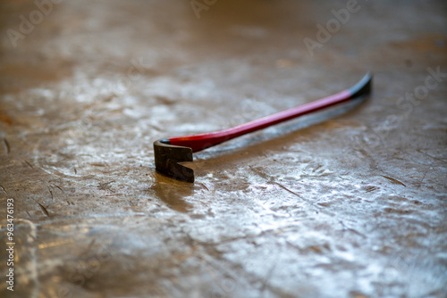 Red crowbar on concrete floor photo