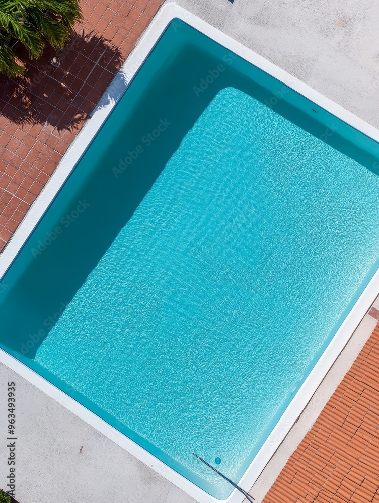 Fototapeta premium An aerial view of a pristine swimming pool with clear, blue water, showcasing a relaxing and luxurious ambiance. This image symbolizes tranquility, leisure, summer, and a vacation retreat.