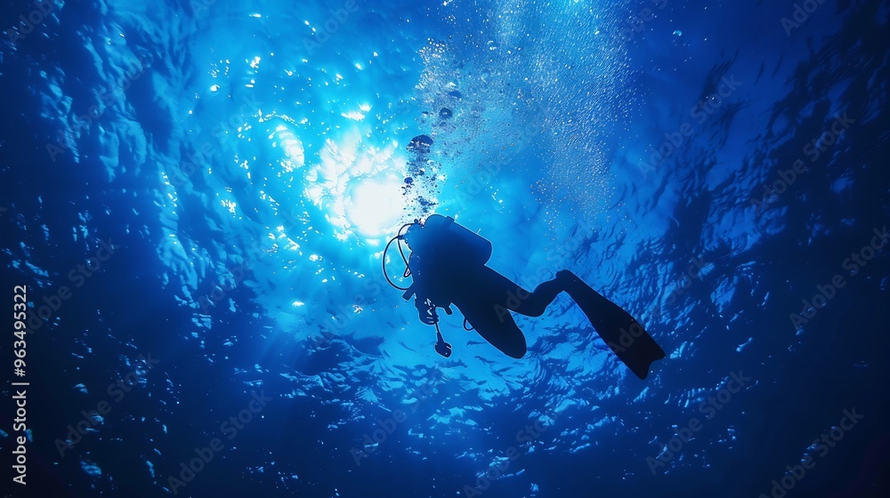 Silhouette of a Scuba Diver Ascending in Blue Water