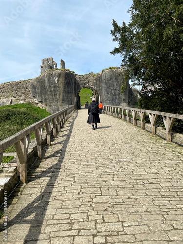 A woman walking to Corfe Castle, Corfe, Dorset, England