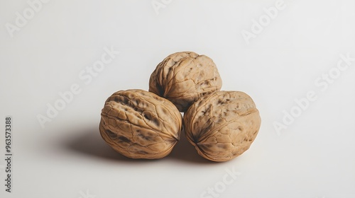 Realistic arrangement of whole walnuts on a white background, focusing on their rough, textured shells and earthy tones with subtle lighting