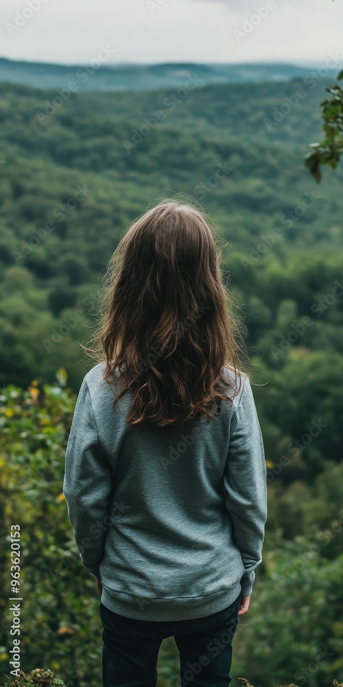 Child standing alone on a hillside overlooking lush green mountains Child standing alone on a hillside overlooking lush green mountains