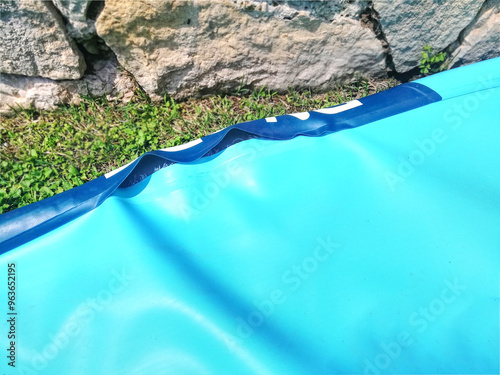 Blue sup board inflatable on the grass with a big hole. Stand Up Paddle board explosed on the sunlight. photo